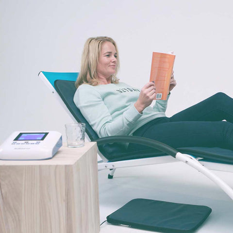 Lady laying on BioBalance mat while reading