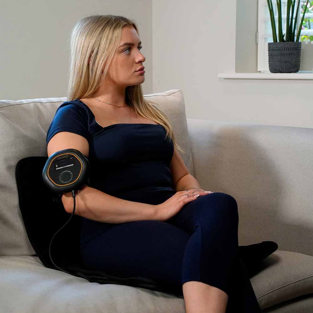 Women sat on CELLER8 Travel Mat while CELLER8 is applied to arm