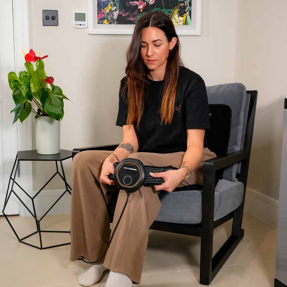 Women sat on CELLER8 Travel Mat while applying CELLER8 to her knee