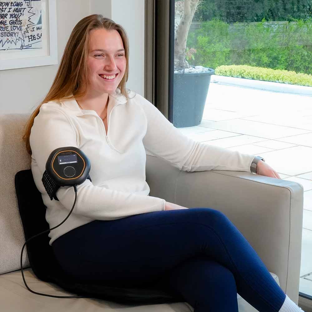 Women sat on CELLER8 Travel Mat while using CELLER8 around her arm