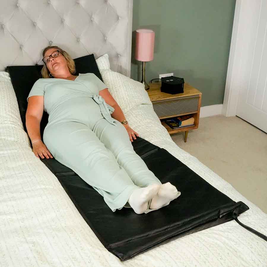 Lady laying on bed using PENTON PRO full body mat